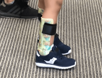 A child wearing custom ankle foot orthoses by Applied Biomechanics.  